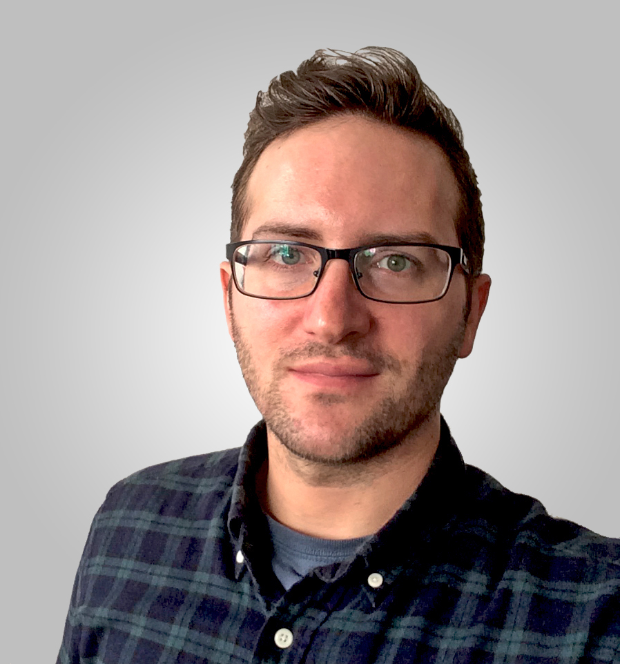 Portrait of Mikael Metthey, wearing glasses and a dark plaid shirt